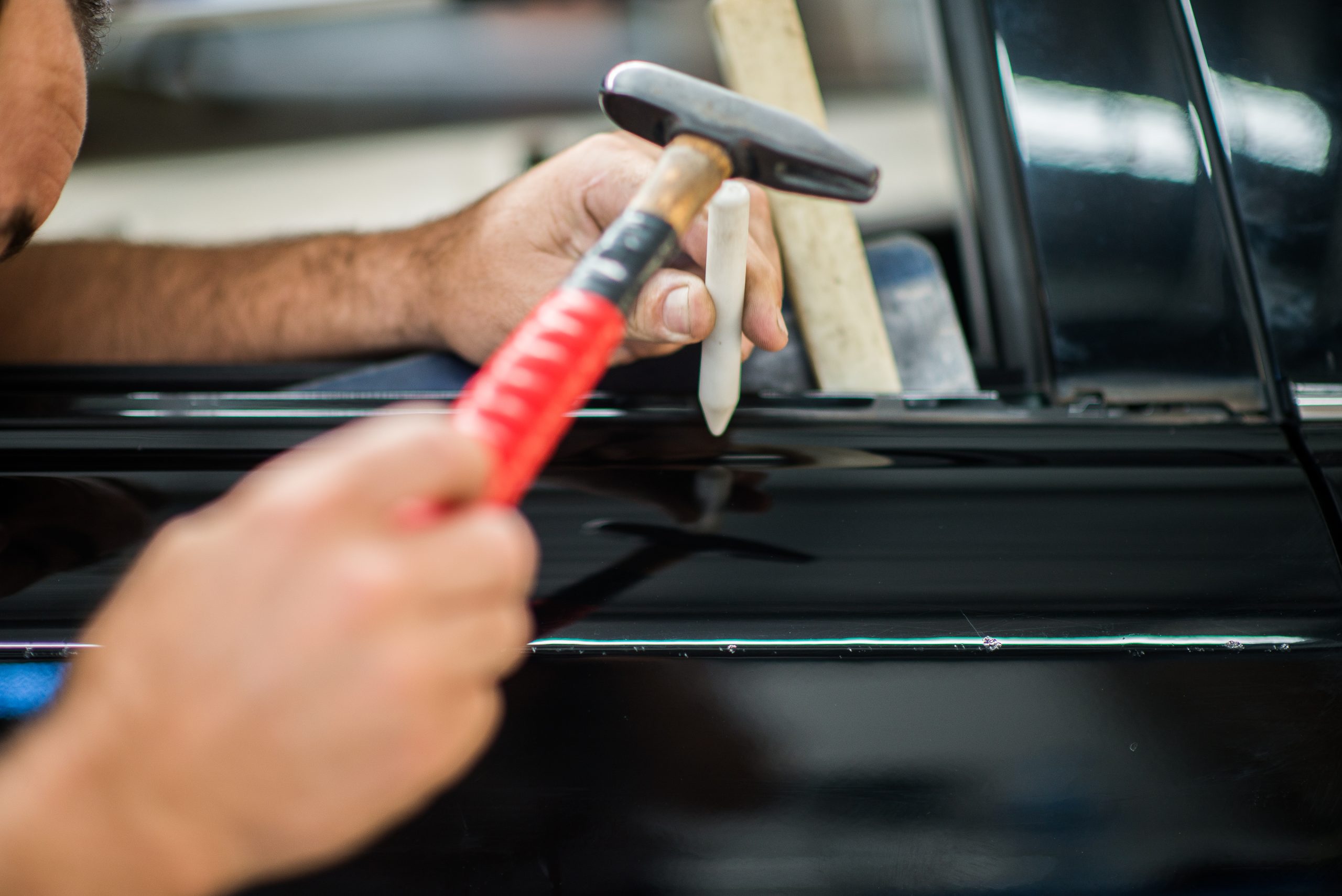 Close-up of a UHR technician working on a vehicle panel